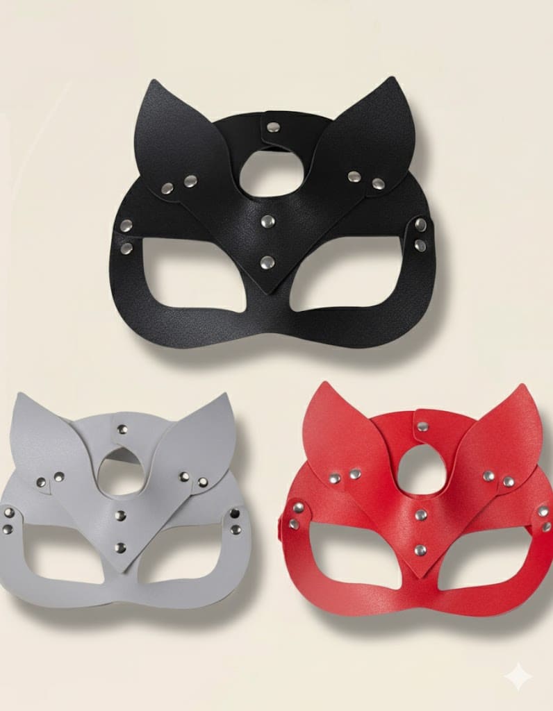 Trois masques en cuir style chat — noir, gris et rouge — présentés ensemble sur fond beige.