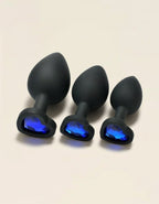 Plug anal noir en silicone doux avec bijou bleu foncé en forme de cœur.